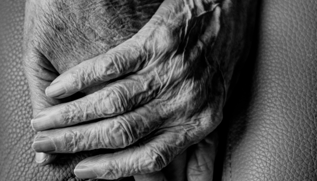 black and white photo of two people holding hands, zoomed in on their hands